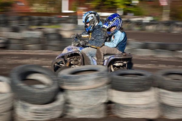 Child loves to race with a quad bike at the muddy quad track — Stock Photo, Image