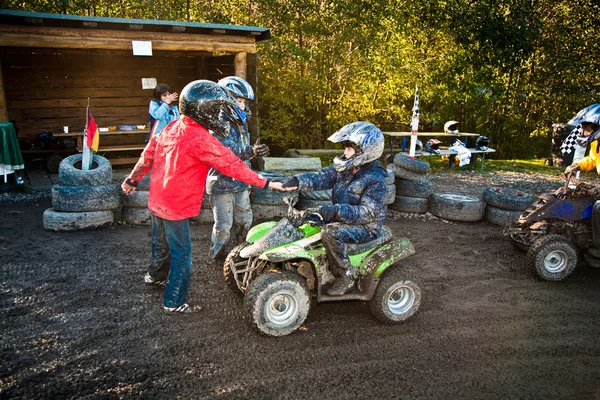 Kind houdt om te racen met een quad bike op de modderige quad circuit — Stockfoto
