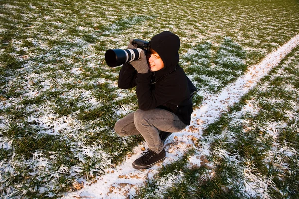 Ragazzo prende una foto in inverno in natura — Foto Stock