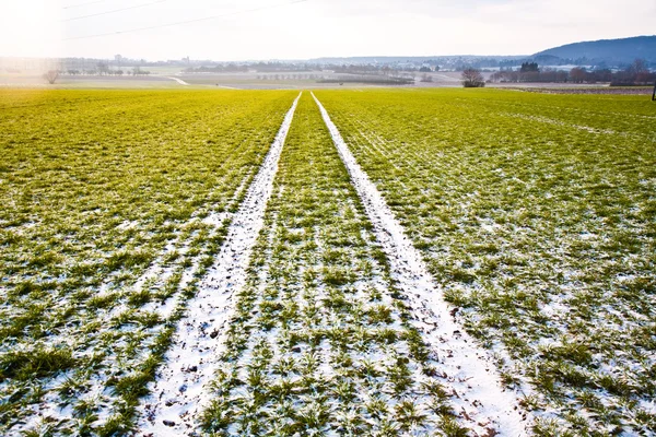 Mark of tyre in field with electrical tower in wintertime — Stock Photo, Image
