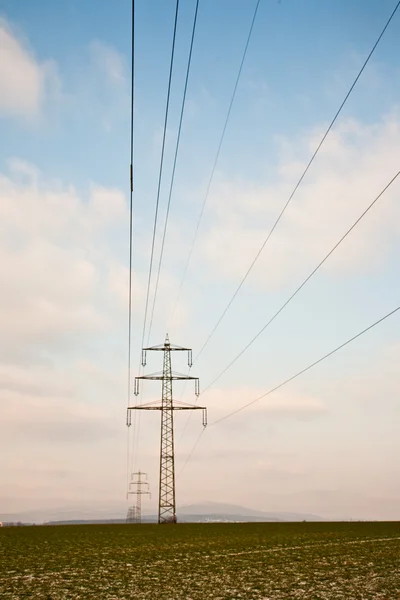 Electrical tower in winter inm rural landscape — Stock Photo, Image