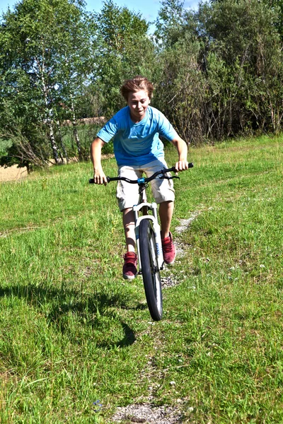 Junge rast mit Fahrrad in Freigelände — Stockfoto