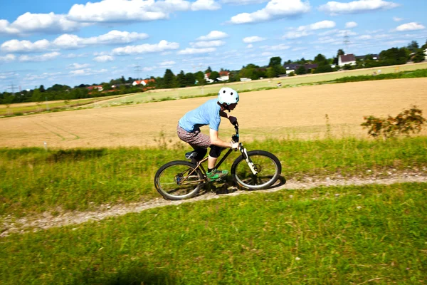 Menino de corrida com sua bicicleta em área aberta — Fotografia de Stock