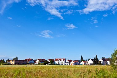 Housing area in rural landscape clipart