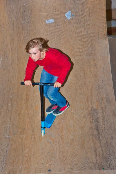Junge springt mit seinem Roller — Stockfoto