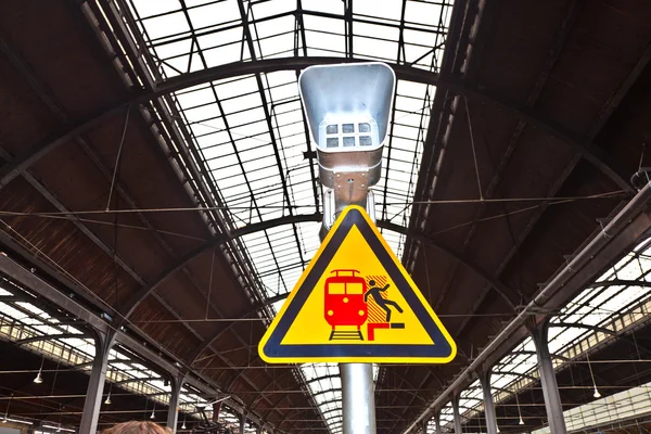 Предупреждающий знак и оратор на классической железнодорожной станции — стоковое фото