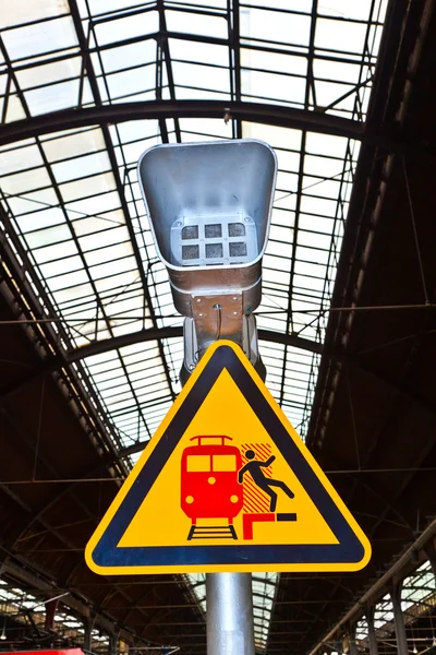 Warning sign and speaker in classicistical railway station — Stock Photo, Image