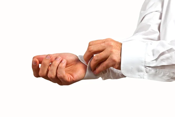 Man closing the sleeve of the white shirt Stock Photo