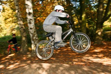 Boy jumping with the BMX Bike at a ramp clipart