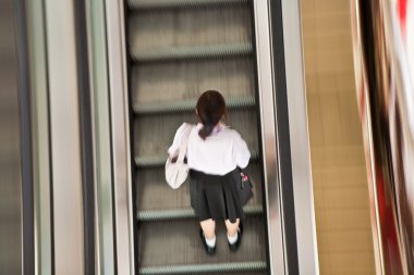 Student on the moving staircase in school dress clipart