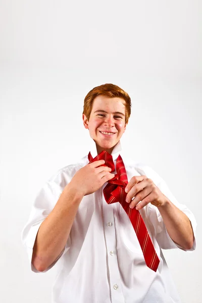 Adolescente vinculando sua gravata vermelha — Fotografia de Stock