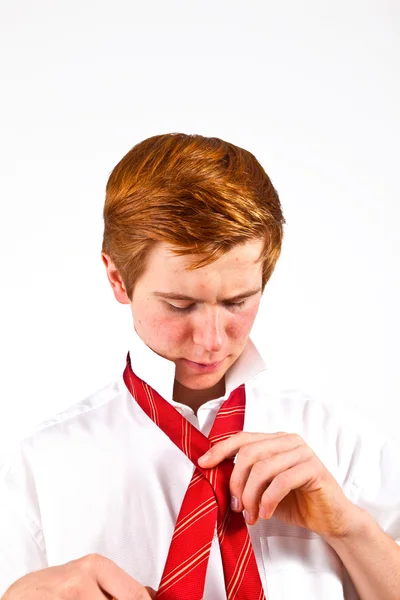 Adolescente vinculando sua gravata vermelha — Fotografia de Stock