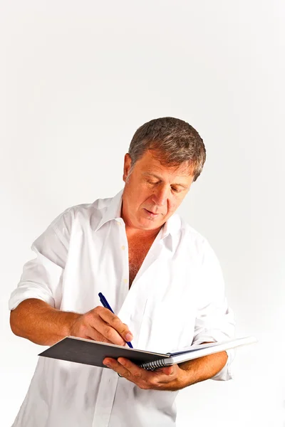 Mann schreibt in einem Buch — Stockfoto