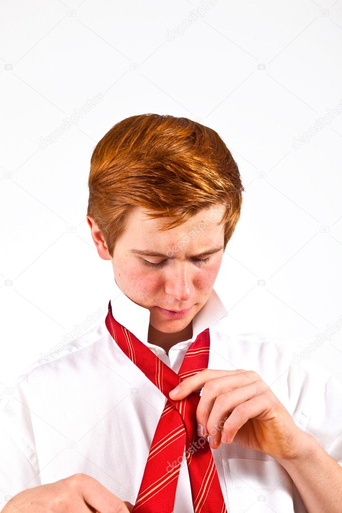 Teenager binding his red tie