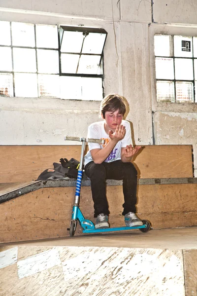 Exhausted boy takes a rest from scooter riding — Stock Photo, Image