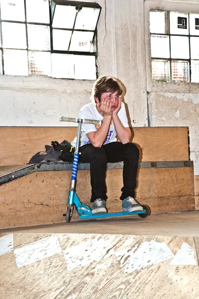 Utmattad pojke tar en paus från skoter — Stockfoto