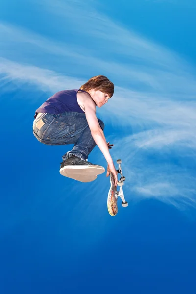 Menino pulando com sua scooter no céu — Fotografia de Stock
