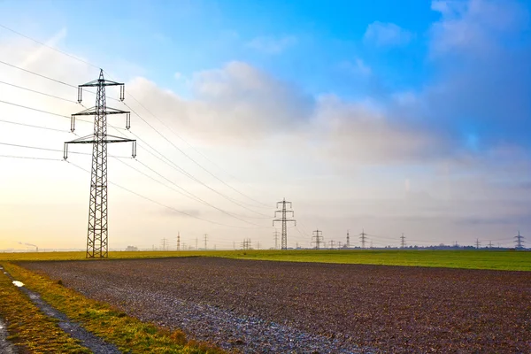 Elektrische toren in landschap met donkere wolken — Stockfoto