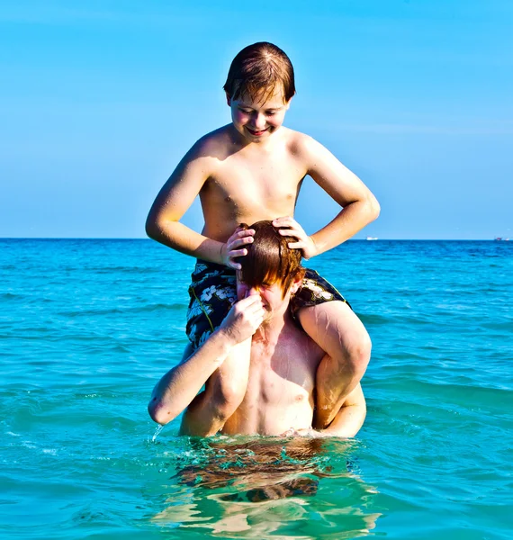 Брати насолоджуються чистою теплою водою на прекрасному пляжі — стокове фото