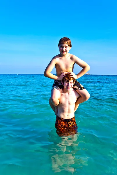 Bratři se těší jasné teplé vody na krásné pláži — Stock fotografie