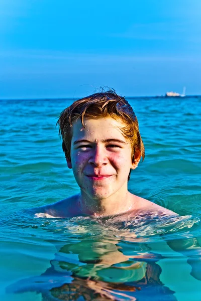 Αγόρι με κόκκινα μαλλιά απολαμβάνοντας το σαφές ζεστό νερό σε την — Φωτογραφία Αρχείου