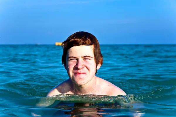 Menino com cabelo vermelho está desfrutando da água morna clara no beauti — Fotografia de Stock