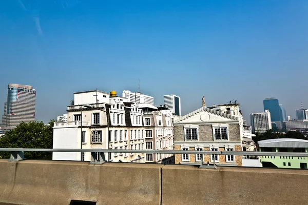 Casa con estatua vista desde carretera con rascacielos en un suburbio —  Fotos de Stock
