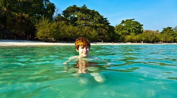 Червоне волосся хлопчик насолоджується красивим чистим морем і розважається — стокове фото