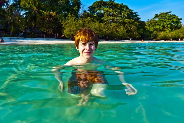 Czerwone włosy chłopak cieszy się krystalicznie czysta woda w morzu — Zdjęcie stockowe