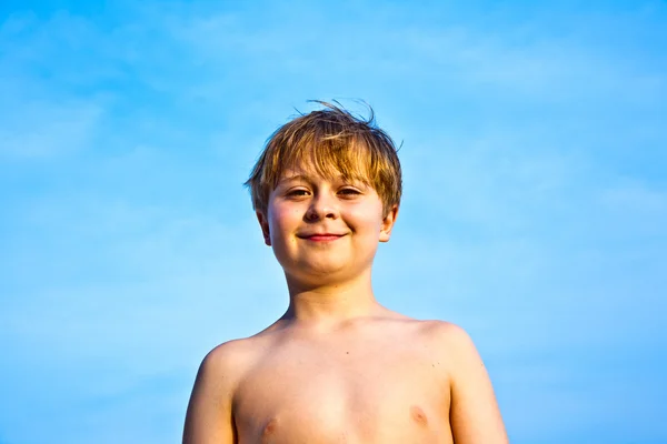 Niño feliz en la playa sonríe y muestra su felicidad —  Fotos de Stock
