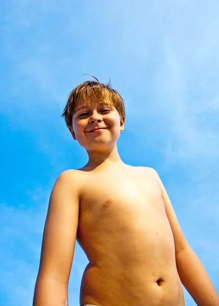 Счастливый мальчик на пляже улыбается и показывает свое счастье — стоковое фото