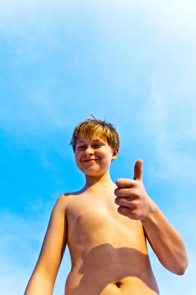 Щасливий хлопчик на пляжі посміхається і показує своє щастя — стокове фото