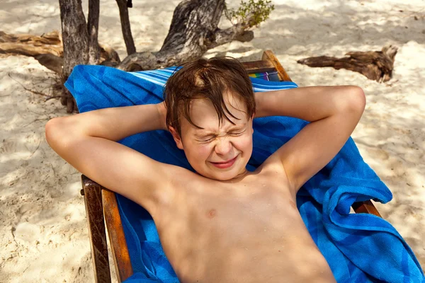 Χαριτωμένο αγόρι στην παραλία κλείνει τα μάτια λόγω φωτεινό sunlig — Φωτογραφία Αρχείου
