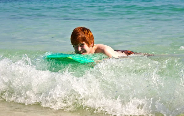 Мальчик получает удовольствие от серфинга на волнах — стоковое фото