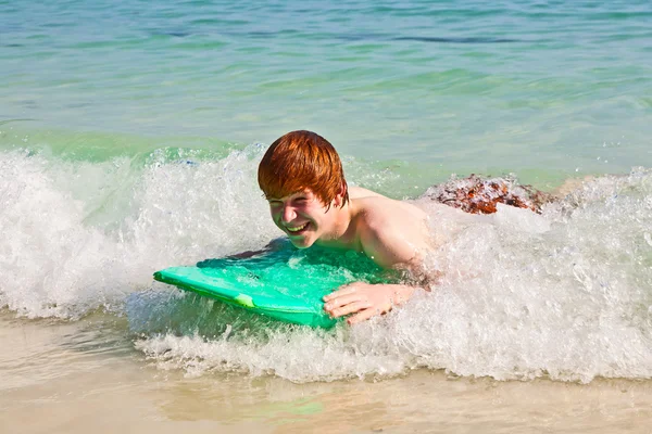 Мальчик получает удовольствие от серфинга на волнах — стоковое фото