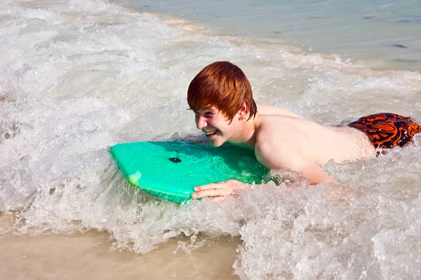 Pojken har roligt surfa i vågorna — Stockfoto