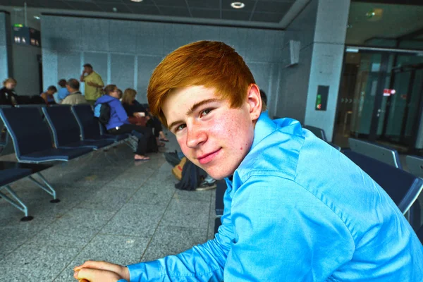 Chłopiec czeka w bramie na lotnisku na wezwanie na pokład — Zdjęcie stockowe