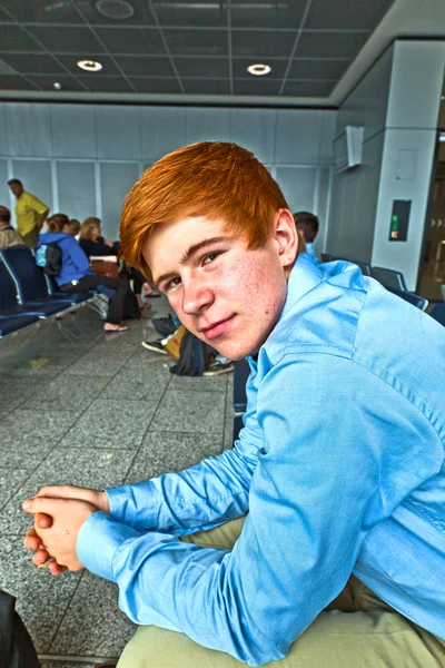 Jongen te wachten in de poort op de luchthaven voor de oproep van de aanhouding — Stockfoto