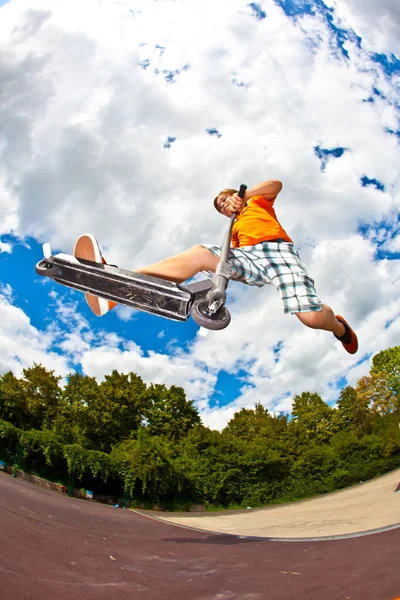 Jongen gaan vanuit de lucht met zijn scooter — Stockfoto