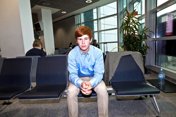 Fiú vár a repülőtéren, beszállás a felhívást kapun — Stock Fotó