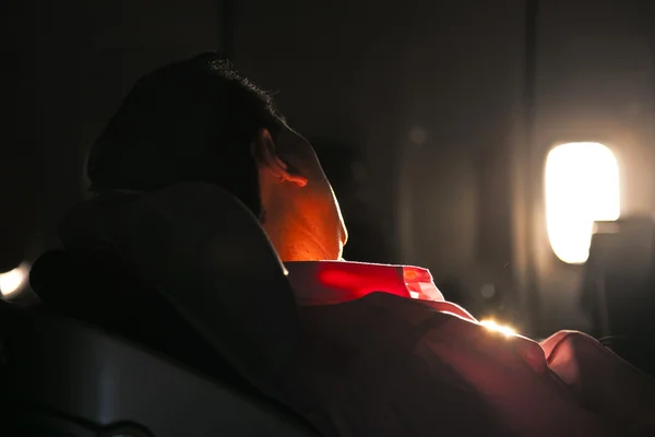 Człowiek śpi w fotelu samolotu w sunrise — Zdjęcie stockowe