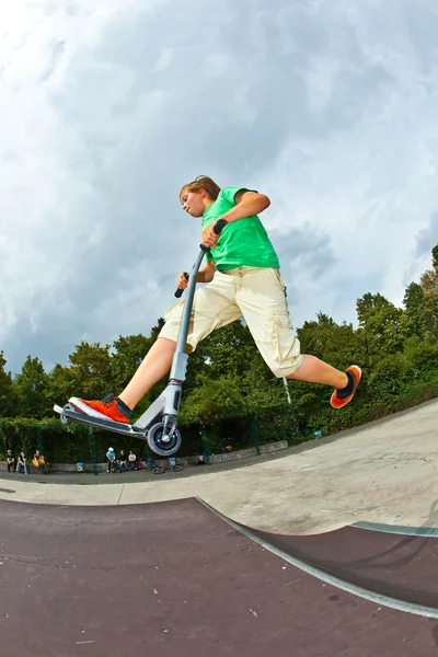 Niño saltando en el aire con su scooter — Foto de Stock