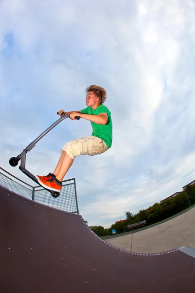 在与自己的滑板车空中跳跃的男孩 — 图库照片