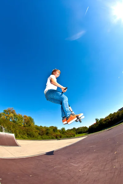 Pojken hoppar med sin skoter — Stockfoto