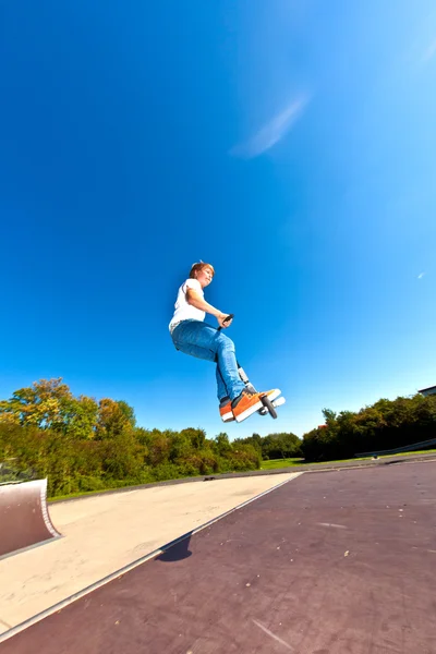 Junge springt mit seinem Roller — Stockfoto