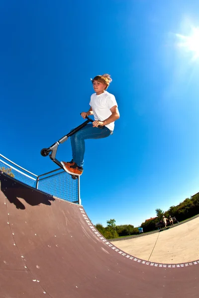 Pojken hoppar med sin skoter — Stockfoto