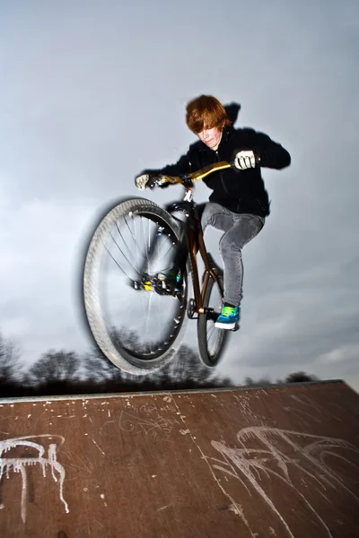 Мальчик прыгает на своем грязном велосипеде — стоковое фото