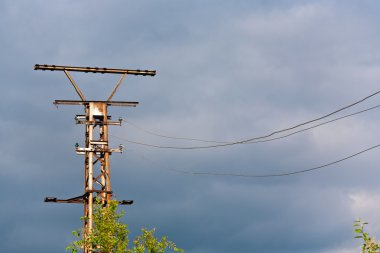 eski paslı elektrikli kule ile kara bulutlar