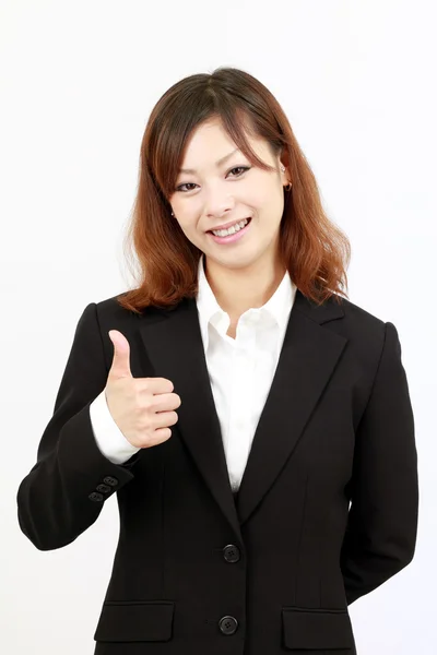 Smiling businesswoman giving thumb up and standing — Stock Photo, Image