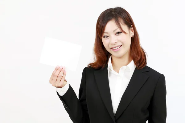 Happy woman holding blank card and smiling — Stock Photo, Image